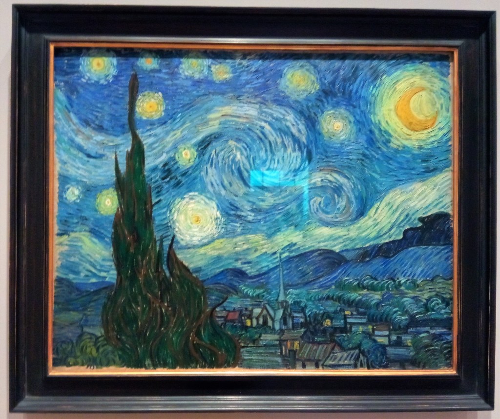 van gogh's starry night. blurry swirls of light and cloud like fuzzy eyes in a wheat sky. tall brush in the foreground. sleepy cottage houses from above, then rolling hills